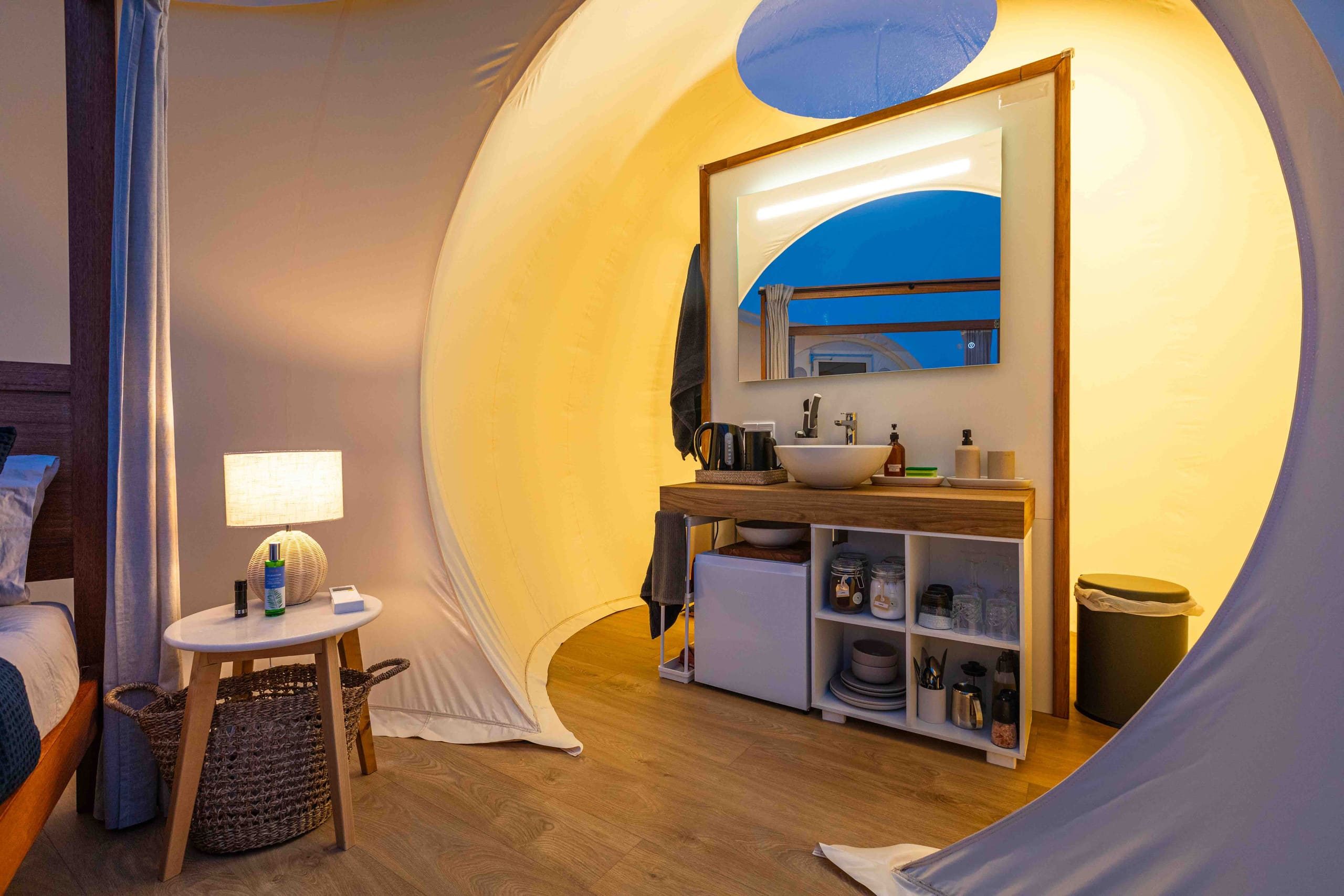 Warmly lit interior with bed and kitchenette at dusk